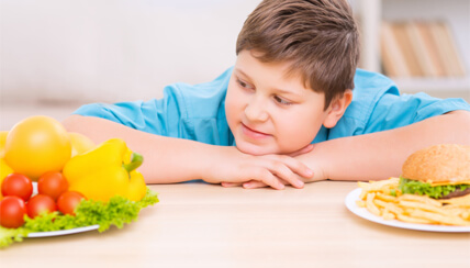 Child at table looking at vegetables