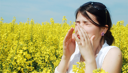 woman in field holding her nose