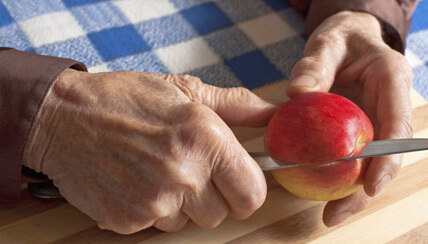 Woman cutting an apple with a butter knife