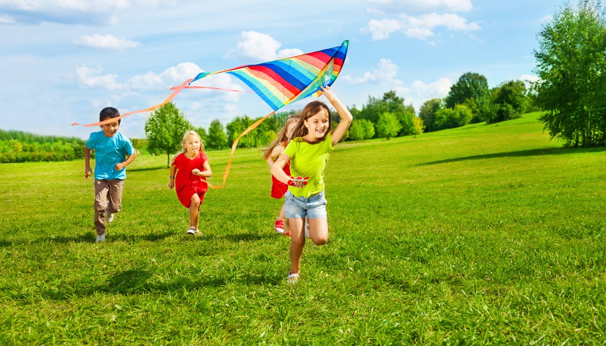 Clean Air Project Banner Image of kids flying a kite in a green field