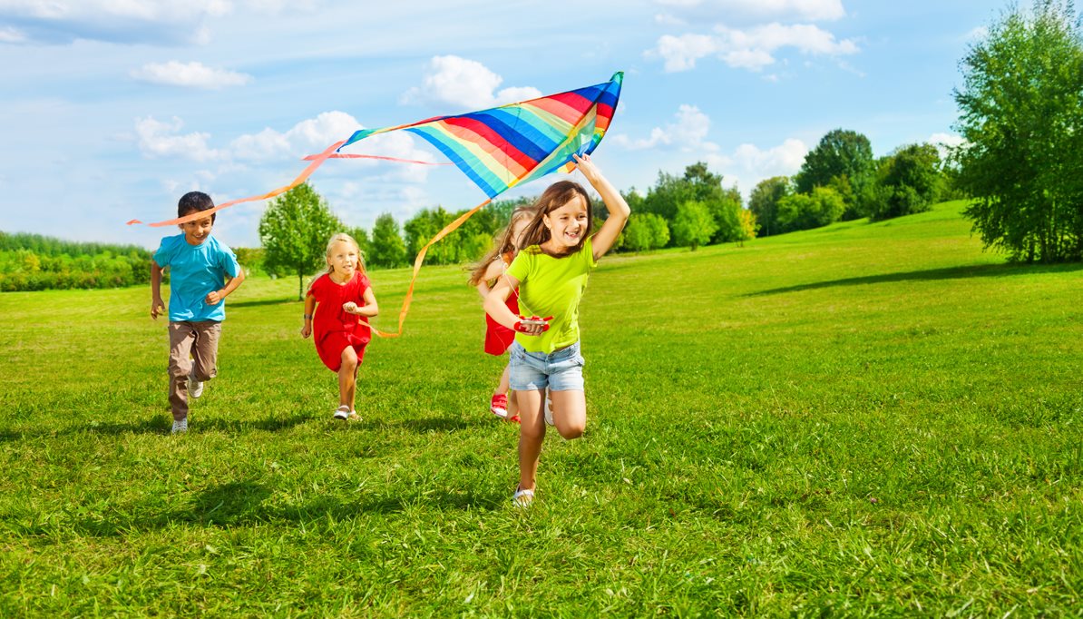Clean Air Project Banner Image of kids flying a kite in a green field