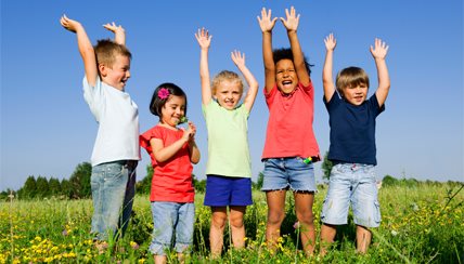 Kids with hands in the air in the middle of a field