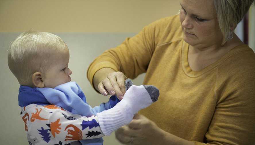 putting socks on baby's hands