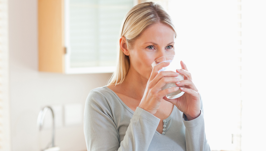 Woman drinking out of a glass.