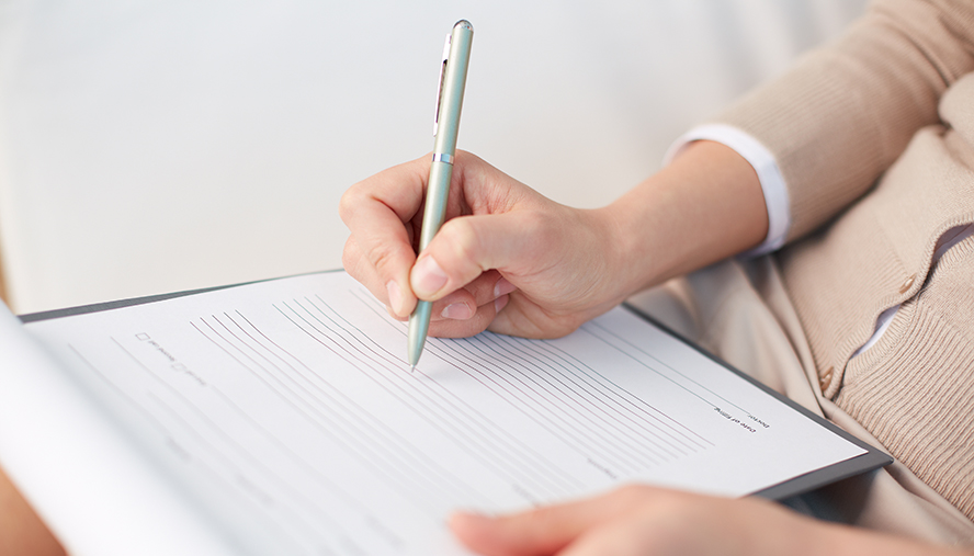 Parent filling out a hard copy of their child's health action plan.