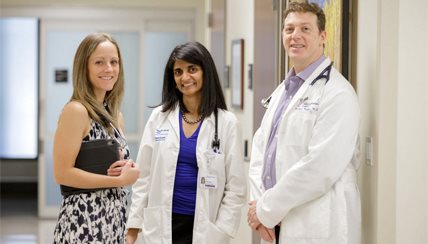 Three doctors smiling at the camera