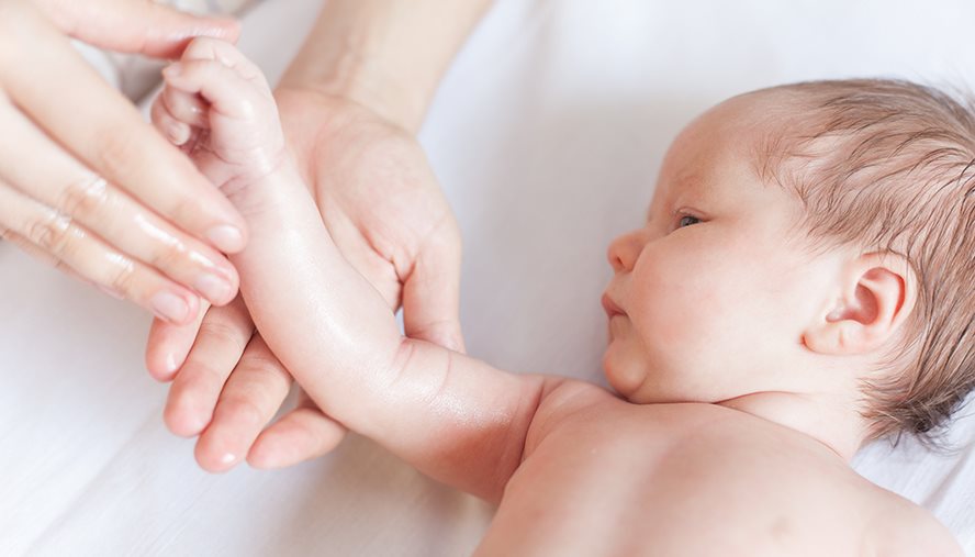 person applying lotion to their baby