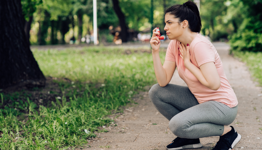 woman using her inhaler while jogging