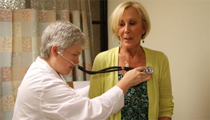 Doctor using stethoscope on patient