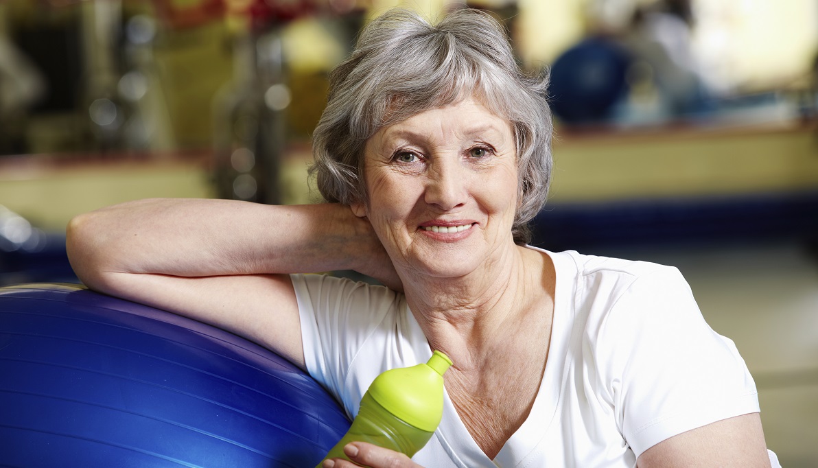 Woman leaning on exercise ball at home