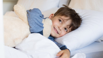 Young boy laying in bed