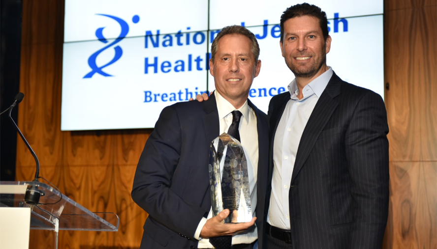 Jonathon K. Yormak of East End Capital presents David A. Falk of Newmark Knight Frank with the National Jewish Health Irving Borenstein Memorial Award. Yormak received the same award in 2016.