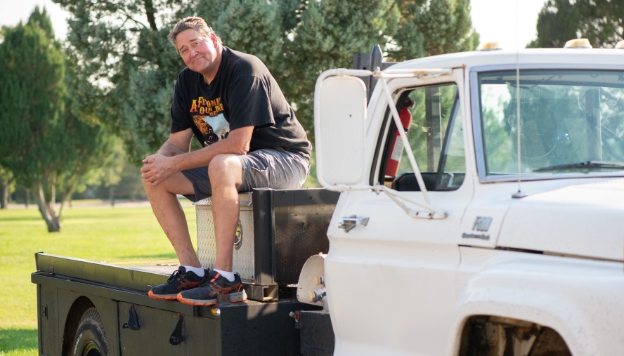 Rodney sitting on the flatbed toolbox of his truck