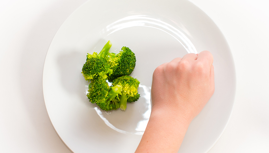 A fist next to a portion of broccoli