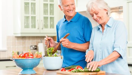 Older couple making a salad in the kitchen