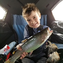 Noah Fitzsimmons holding a trout