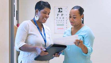 doctor and nurse conferring over a patient's chart doctor and nurse conferring over a patient's chart