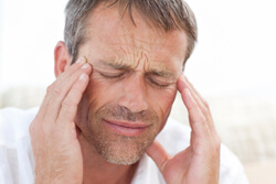 Stressed out man rubbing his temples