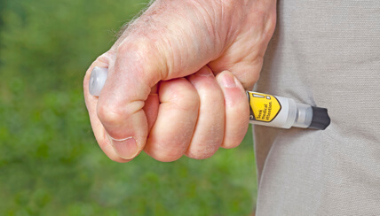 EpiPen being used on a leg EpiPen being used on a leg
