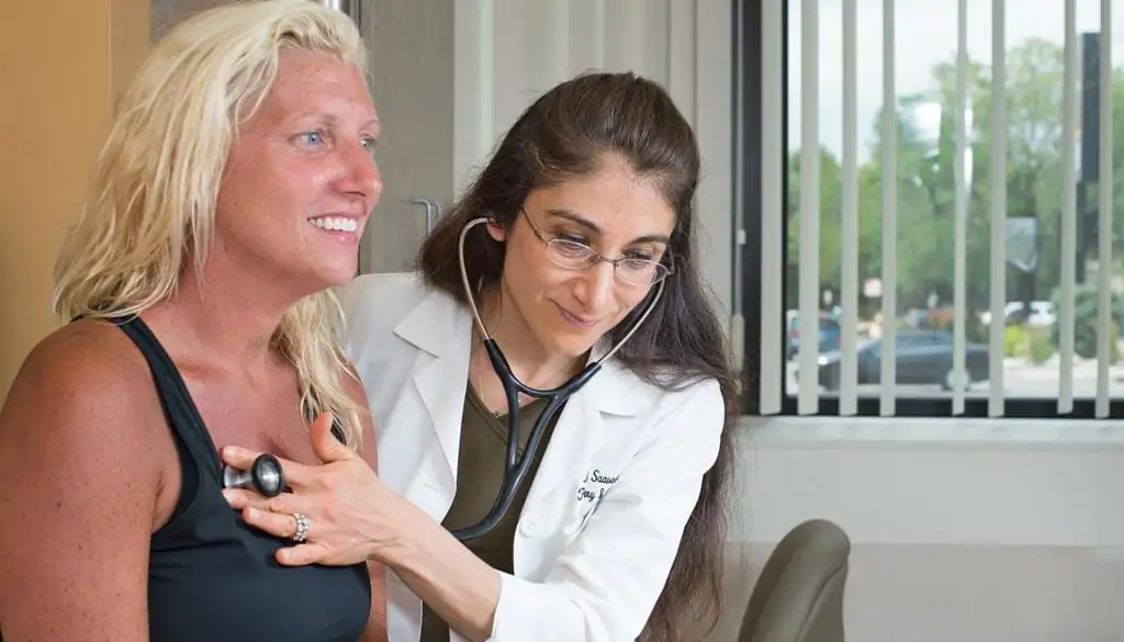 Physician taking heart beat
