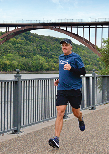 Kevin Buron jogging next to a river