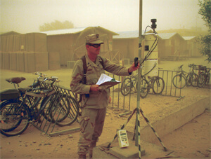 Iraq veteran Dr. Richard Meehan testing air quality in a dust storm in the Middle East.