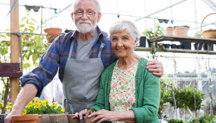 two seniors smiling in a flower shop