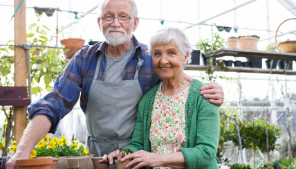 two seniors smiling in a flower shop two seniors smiling in a flower shop