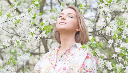 Woman smelling blooming tree